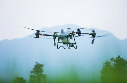 DJI T50 Spraying Drone flying over a snowy landscape with trees in the foreground